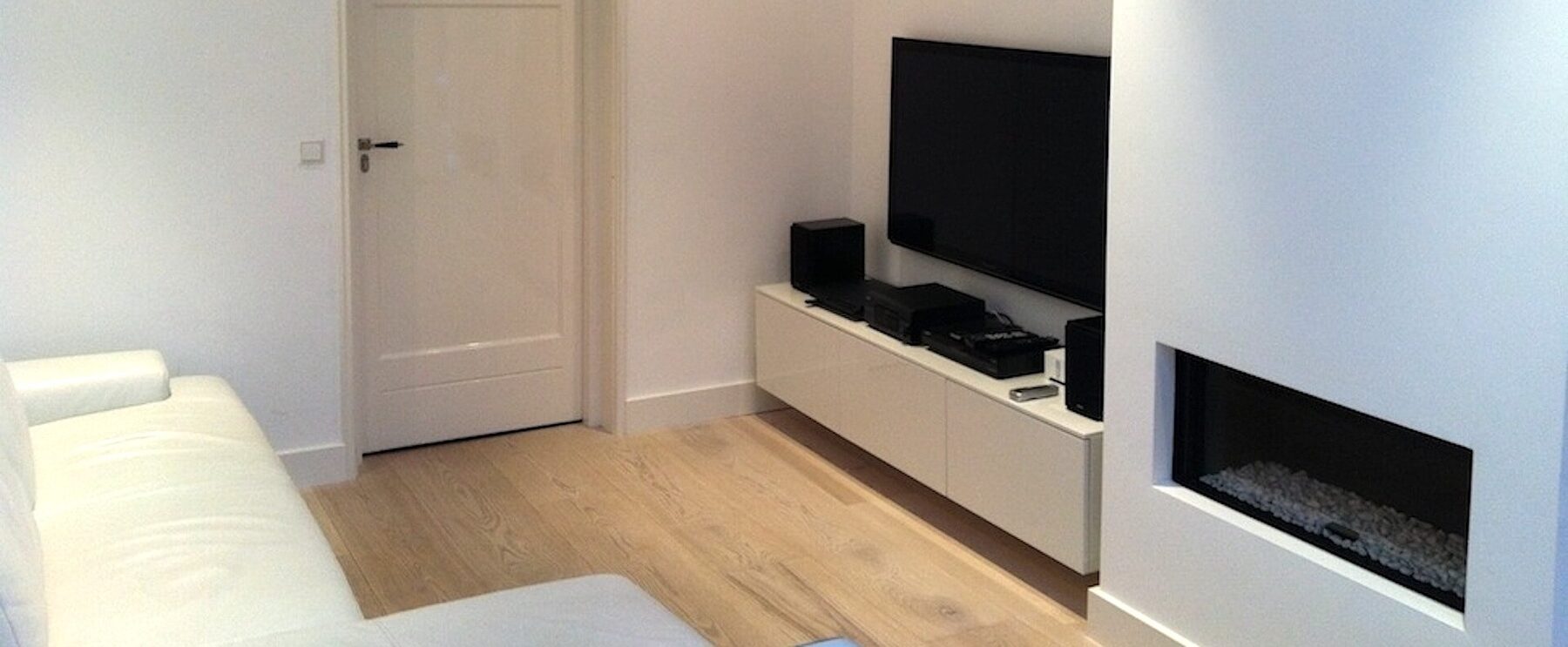 Strak afgewerkte woonkamer met inbouwhaard